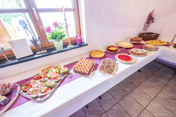 Candy bar pink wedding decorated standing of festive table with deserts, strawberry tartlet and cupcakes