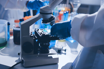 Scientist pipetting medical samples into microplate in laboratory
