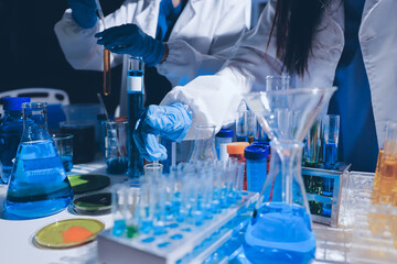 Scientist pipetting medical samples into microplate in laboratory