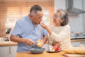 Couple enjoys cooking together in a bright kitchen while sharing a playful moment with fresh ingredients