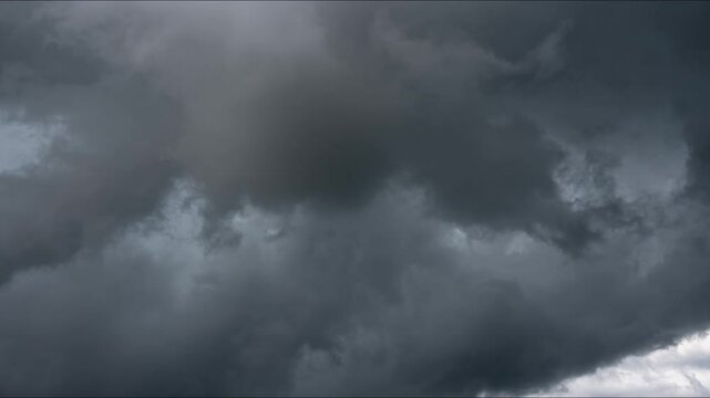 Dark storm clouds moving. Heavy, dark storm clouds rapidly form and swirl in a dramatic Timelapse. The sky becomes increasingly ominous, creating a powerful visual of approaching weather.