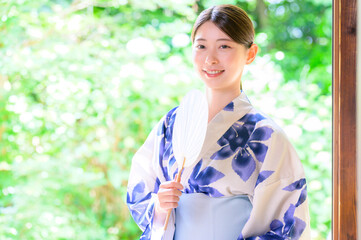 浴衣姿の女性が団扇を手に見せる涼やかな夏の笑顔