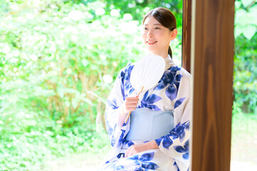 浴衣姿の女性が団扇を手に夏の涼を楽しむ笑顔のひととき
