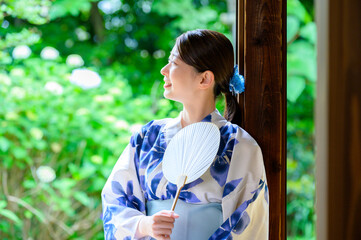 浴衣姿の女性が団扇を手に涼やかに微笑む穏やかな夏の午後