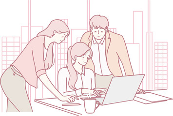 A dynamic team collaborates on a shared laptop, showcasing teamwork and innovation in a vibrant workplace