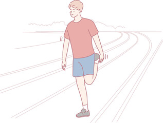 A young man is performing a leg stretch on a track, diligently preparing himself for a vigorous exercise