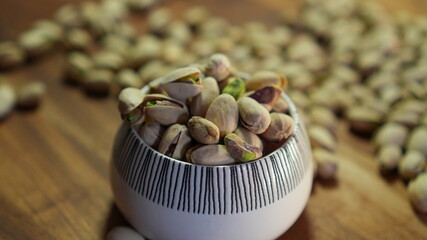 Full Bowl of Pistachios on Wooden Surface – Natural Light and Warm Ambiance