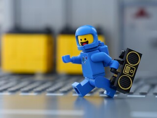 Obraz premium Tambov, Russian Federation - May 30, 2025 Blue Lego astronaut minifigure running with boombox.