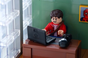 Obraz premium Tambov, Russian Federation - February 12, 2025 Lego Peter Parker minifigure working behind a laptop on his office workplace