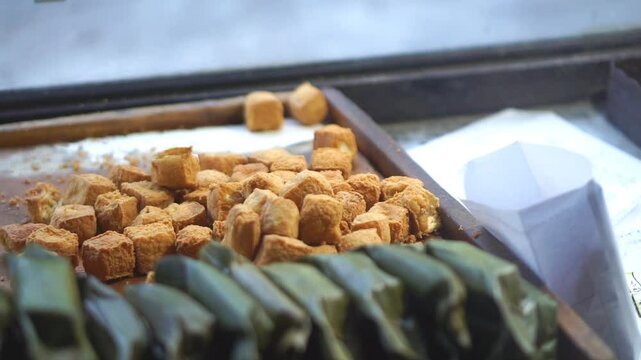 The hands of a Sumedang tofu trader counting the tofu ordered by his customer
