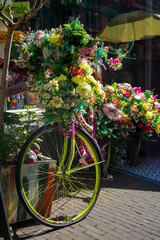 Old vintage woman bicycle decorated with pink flowers on small bridge in old part of Deventer. High quality photo
