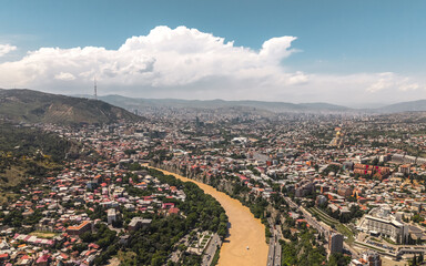 Urban landscape of Tbilisi. Aerial view of city buildings, streets, and hills