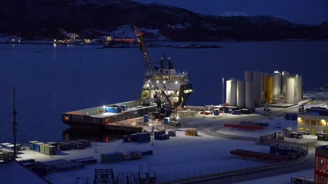 Mobile crane unloads containers from the offshore supply vessel Troms Arcturus at Vestbase in Norway