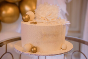 Elegant Golden Wedding Cake with White Floral Decoration on a Silver Stand, Luxurious Celebration Dessert Photography