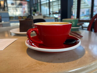 Cafe. Red cup of cappuccino on the table.