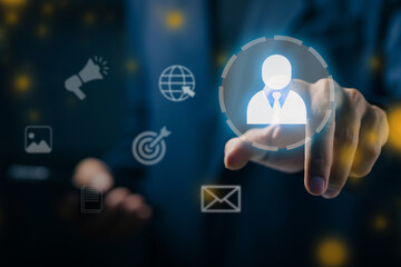 Businessman touching virtual user icon with digital marketing and communication symbols, representing CRM, target audience, and customer relationship management technology.