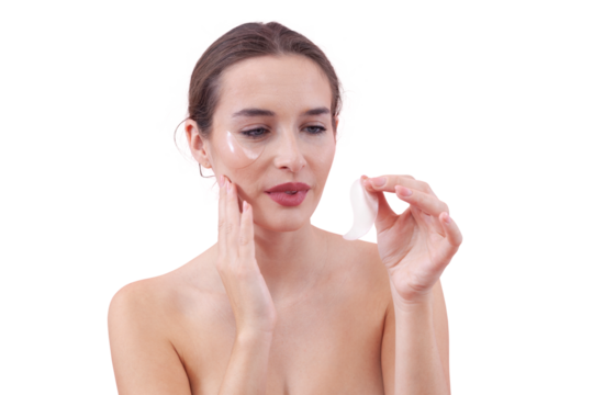 Portrait of a young woman with a natural makeup look, applying silicone under eye patches. Skincare concept for dark circles, isolated on white background
