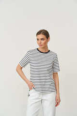 Woman in a short-sleeved black and white striped shirt with a round neck. She has light brown hair...