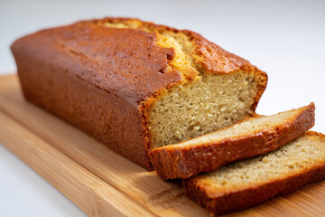 Freshly baked loaf of banana bread presented on a wooden cutting board with slices cut and ready for serving