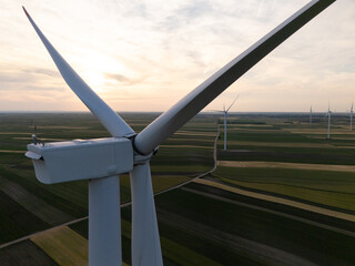 Aerial view of wind turbine on an agricultural filed at sunset. Close up of blades