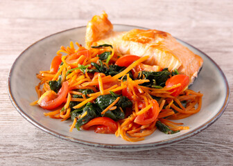 Salmon with carrot and spinach on plate