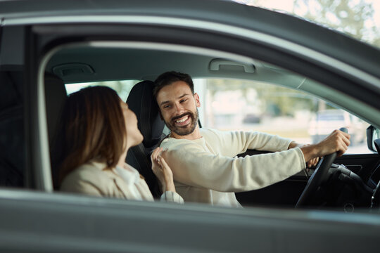 Happy couple communicating while going on a journey with a car. 