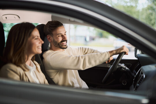 Happy couple communicating while going on a journey with a car. 