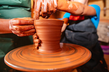 Hands of Adult and Child Making Pottery