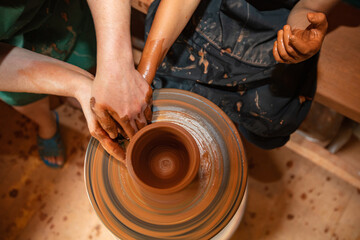 Hands of Adult and Child Making Pottery