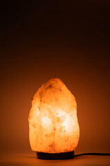 Glowing pink salt lamp on dark background.
