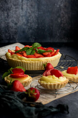 Homemade Strawberry Tart with Cream and Mint on Rustic Background