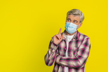 Caucasian middle-aged ill man wearing medical mask on face prevention protection safety bronchitis asthma allergy flu pneumonia virus disease problem. Sick mature guy isolated on yellow background