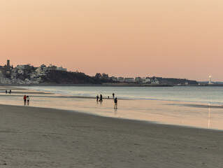 people walking on beach at sunset at lowtide