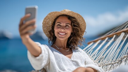 A smiling woman enjoys a sunny day on the beach while taking a selfie, embodying the spirit of summer and relaxation in a picturesque seaside setting filled with joy.