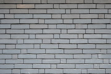 Stone wall with much gray bricks of the modern building.