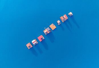 Unique floating houses arranged in a linear formation over clear blue water