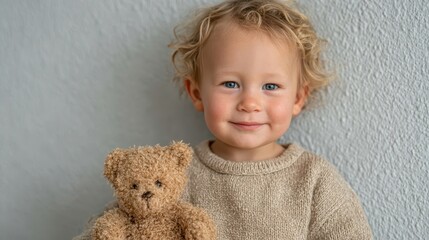 A happy child poses with a teddy bear, showcasing innocence and joy, while highlighting the bond between children and their favorite toys in a playful environment.