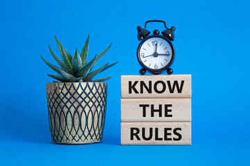 Know the rules symbol. Wooden blocks with words Know the rules. Beautiful blue background with...