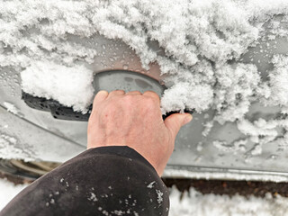 Door handle covered in snow during a cold snap while preparing to leave a vehicle in winter...