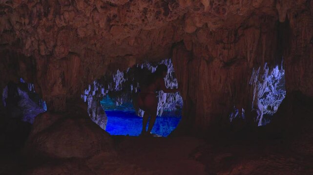 Woman in bikini exploring a cenote cave water 