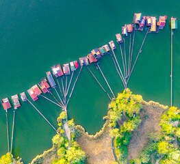 Fishing houses line the serene waters showcasing vibrant colors at sunrise