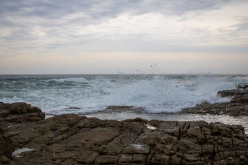 Various waves from the ocean crashing onto the rocks on the south coast of South Africa, located at Orange Rocks in Uvongo in Margate