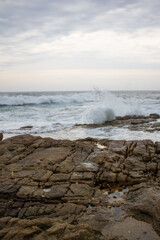 Various waves from the ocean crashing onto the rocks on the south coast of South Africa, located at Orange Rocks in Uvongo in Margate