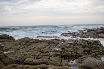 Various waves from the ocean crashing onto the rocks on the south coast of South Africa, located at Orange Rocks in Uvongo in Margate