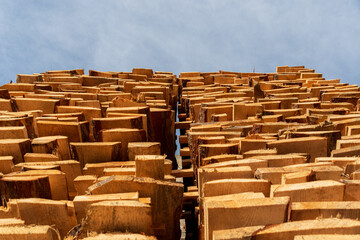 A collection of neatly stacked wood logs rises into the sky, showcasing their natural texture...