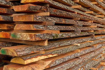 A collection of neatly stacked wooden planks reveals rich textures and colors, illustrating woodworking materials at a lumber yard