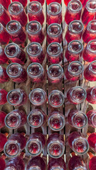 Wine bottles resting horizontally on wooden rack, bottoms upward, revealing rich red wine contents...