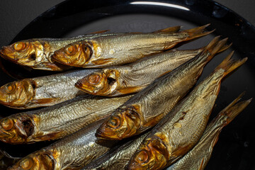 Tasty and salty smoked sprats marinated with salt and spices. Smoked fish marinated with herbs and salt. Smoked fish herring.