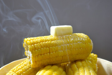 湯気の立ち昇る蒸籠でコーンバターを調理