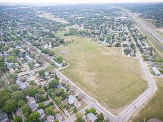 View of a residential area with a large empty field in the middle